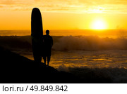 A long boarder watching the waves at sunset in Portugal. Стоковое фото, агентство Ingram Publishing / Фотобанк Лори