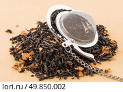 Aromatic black dry tea with petals and a tea strainer on yellow textured background. Стоковое фото, агентство Ingram Publishing / Фотобанк Лори