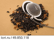 Aromatic black dry tea with petals and a tea strainer on yellow textured background. Стоковое фото, агентство Ingram Publishing / Фотобанк Лори