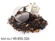 Aromatic black dry tea with petals and a tea strainer on white reflective background. Стоковое фото, агентство Ingram Publishing / Фотобанк Лори