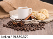 Coffee cup with burlap sack of roasted beans on rustic table. Стоковое фото, агентство Ingram Publishing / Фотобанк Лори