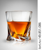 Glass of cognac on a gray background. Стоковое фото, агентство Ingram Publishing / Фотобанк Лори