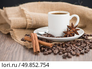 Coffee cup with burlap sack of roasted beans on rustic table. Стоковое фото, агентство Ingram Publishing / Фотобанк Лори