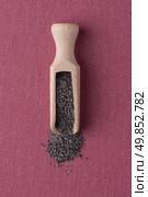 Top view of wooden scoop with poppy seeds against pink vinyl background. Стоковое фото, агентство Ingram Publishing / Фотобанк Лори