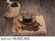 Coffee cup with burlap sack of roasted beans on rustic table. Стоковое фото, агентство Ingram Publishing / Фотобанк Лори