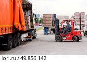 Russia. Samara, June 28, 2024: a forklift unloads a truck with construction materials. Редакционное фото, фотограф Акиньшин Владимир / Фотобанк Лори