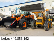 Russia. Samara, August 22, 2024: new construction equipment on the trading platform near the store on a sunny summer day. Text in Russian: gidroremservis. Редакционное фото, фотограф Акиньшин Владимир / Фотобанк Лори