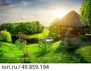 Wooden arbour with thatched roof near river. Стоковое фото, агентство Ingram Publishing / Фотобанк Лори