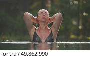 Woman bathing in a pool by the sea at sunrise or sunset. Стоковое видео, видеограф Igor Skripachev / Фотобанк Лори