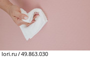 A woman's hand wipes water drops from a beige rug with a white cloth. Стоковое видео, видеограф Катерина Белякина / Фотобанк Лори