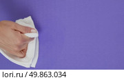 A woman's hand wipes drops of water from a lilac rug with a white cloth. Стоковое видео, видеограф Катерина Белякина / Фотобанк Лори