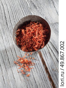 saffron in old spoon on wooden background. saffron in spoon on wooden background. Стоковое фото, агентство Ingram Publishing / Фотобанк Лори