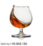 Splash of cognac in glass isolated on white background. Стоковое фото, агентство Ingram Publishing / Фотобанк Лори