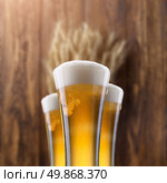 Glass of beer with wheat on wooden background. Стоковое фото, агентство Ingram Publishing / Фотобанк Лори
