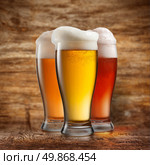 Different beer in glasses on wooden background. Стоковое фото, агентство Ingram Publishing / Фотобанк Лори