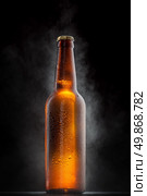 Cold beer bottle with drops, frost and vapour on black. Стоковое фото, агентство Ingram Publishing / Фотобанк Лори