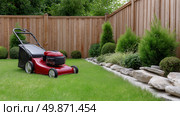 Lawn maintenance with a red mower in a well-kept backyard garden. Стоковое AI-изображение, AI-художник Katsiaryna Repich / Фотобанк Лори