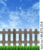 Picket wood fence on a blue sky with green grass in the foreground with weathered old grunge texture as a residential design element. Стоковое фото, агентство Ingram Publishing / Фотобанк Лори