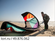 Kitesurfer prepating his equipment on a beautiful sunset at the beach. Стоковое фото, агентство Ingram Publishing / Фотобанк Лори