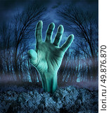 Zombie hand rising out of the ground in a spooky dark forest with creepy trees and fog as a symbol of Halloween imagination with a dangerous monster coming back from the dead. Стоковое фото, агентство Ingram Publishing / Фотобанк Лори