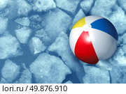 Cold summer weather concept with a plastic inflatabe beach ball stuck in frozen ice in a freezing pool as a symbol of leisure activity problems caused by colder temperatures during vacations and family holidays. Стоковое фото, агентство Ingram Publishing / Фотобанк Лори
