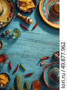 Colorful Fiesta Celebration Layout Featuring Hats, Snacks, and Drinks on Blue Wooden Table. Стоковое AI-изображение, AI-художник Юлия Гапеенко / Фотобанк Лори