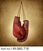 Boxing gloves hanging on an old vintage grunge background with laces nailed to a wall as a business or sport concept of retirng giving up the fight or preparing for competition. Стоковое фото, агентство Ingram Publishing / Фотобанк Лори