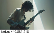 A man with long hair playing a guitar. Стоковое AI-изображение, AI-художник Данила Большаков / Фотобанк Лори