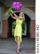 A beautiful elderly woman with a bouquet of flowers walks through the streets of the city. Age model blonde in full growth. A woman in her fifties in a beautiful dress. Стоковое фото, фотограф Лазаренко Светлана / Фотобанк Лори