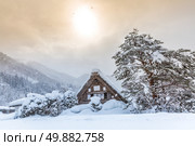 Shirakawago with Snowfall and winter Sun,  Gifu Chubu Japan. Стоковое фото, агентство Ingram Publishing / Фотобанк Лори