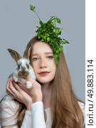 A rural girl with a bunch of parsley on her head is holding a pockmarked rabbit. Стоковое фото, фотограф Лазаренко Светлана / Фотобанк Лори