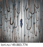 Escape the lure and avoiding risk and the dangers of being hooked business concept as a businessman climbing a fishing line escaping dangerous fish hooks as a metaphor for   freedom from addiction. Стоковое фото, агентство Ingram Publishing / Фотобанк Лори