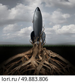 Rooted down concept with an aging rocket ship being held down by growing tree roots as a metaphor for uncompetitive and abandoned strategy of past forgotten potential and broken dreams of glory. Стоковое фото, агентство Ingram Publishing / Фотобанк Лори
