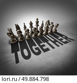 Together concept and team effort symbol as a group of chess pieces in a set casting a shadow with the word representing partnership solidarity in a company or union of workers. Стоковое фото, агентство Ingram Publishing / Фотобанк Лори