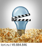 Movie idea concept and cinema creativity symbol as a light bulb or lightbulb in popcorn shaped as an open clap board or video slate as a metaphor for finding new entertainment ideas. Стоковое фото, агентство Ingram Publishing / Фотобанк Лори