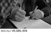 A person is writing on a piece of paper with a pen, focusing intently on the task at hand. Стоковое AI-изображение, AI-художник Данила Большаков / Фотобанк Лори