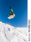 Snowboarder executing a radical jump against blue sky. Стоковое фото, агентство Ingram Publishing / Фотобанк Лори