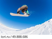 Snowboarder executing a radical jump against blue sky. Стоковое фото, агентство Ingram Publishing / Фотобанк Лори