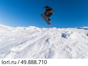 Snowboarder executing a radical jump against blue sky. Стоковое фото, агентство Ingram Publishing / Фотобанк Лори