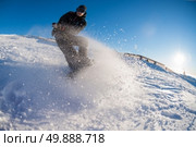 Snowboard freerider in the mountains against sun shine in blue sky. Стоковое фото, агентство Ingram Publishing / Фотобанк Лори