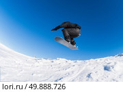 Snowboarder executing a radical jump against blue sky. Стоковое фото, агентство Ingram Publishing / Фотобанк Лори