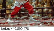 A person wearing red pants and a white shirt is executing a trick skillfully. Стоковое AI-изображение, AI-художник Данила Большаков / Фотобанк Лори