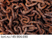 Rusted old iron chains background as a stack of oxidized decaying metal links as an abstract symbol of industrial aging or corrosion. Стоковое фото, агентство Ingram Publishing / Фотобанк Лори