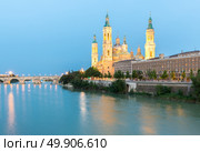 Our Lady of the Pillar Basilica with Ebro River at dusk Zaragoza, Spain. Стоковое фото, агентство Ingram Publishing / Фотобанк Лори
