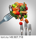 Feed the poor concept as a giant fork with bountiful food feeding smaller dirty forks as a symbol for taking care of the less fortunate and the needy as an act of charity and generosity with 3D illustration elements. Стоковое фото, агентство Ingram Publishing / Фотобанк Лори