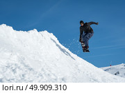 Snowboarder executing a radical jump against blue sky. Стоковое фото, агентство Ingram Publishing / Фотобанк Лори