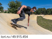 Skateboarder practice on a pump track park on a sunny summer day. Стоковое фото, агентство Ingram Publishing / Фотобанк Лори