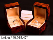 Platinum Diamond Ring, Wedding rings in a box on dark background with warranty card blurred. Стоковое фото, агентство Ingram Publishing / Фотобанк Лори