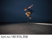 Skateboarder performing a ollie flip on a concrete pavement along the harbour. Стоковое фото, агентство Ingram Publishing / Фотобанк Лори