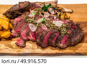 Grain fed Grilled Tomahawk Beef steak with fried potato wedge. Стоковое фото, агентство Ingram Publishing / Фотобанк Лори